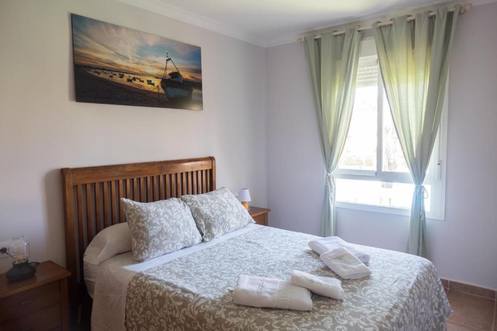 诺沃桑克蒂佩特里Apartamento Jardin del Golf的一间卧室配有一张床,上面有两条毛巾