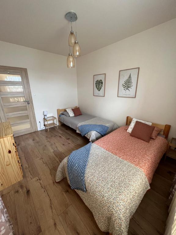 苏瓦乌基Apartament Poznańska的铺有木地板的客房内的两张床