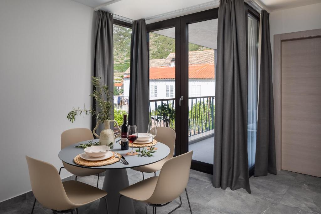 科米扎Residence THE ONE - new的一间带桌椅和窗户的用餐室