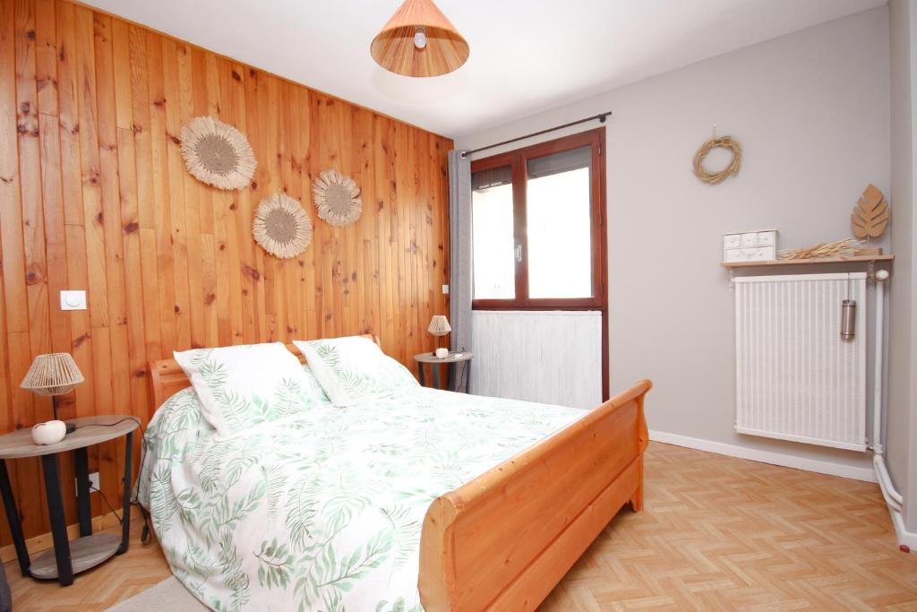 布里昂松Coquet appartement Type 2 de 56 m² en centre ville的一间卧室配有一张木墙床
