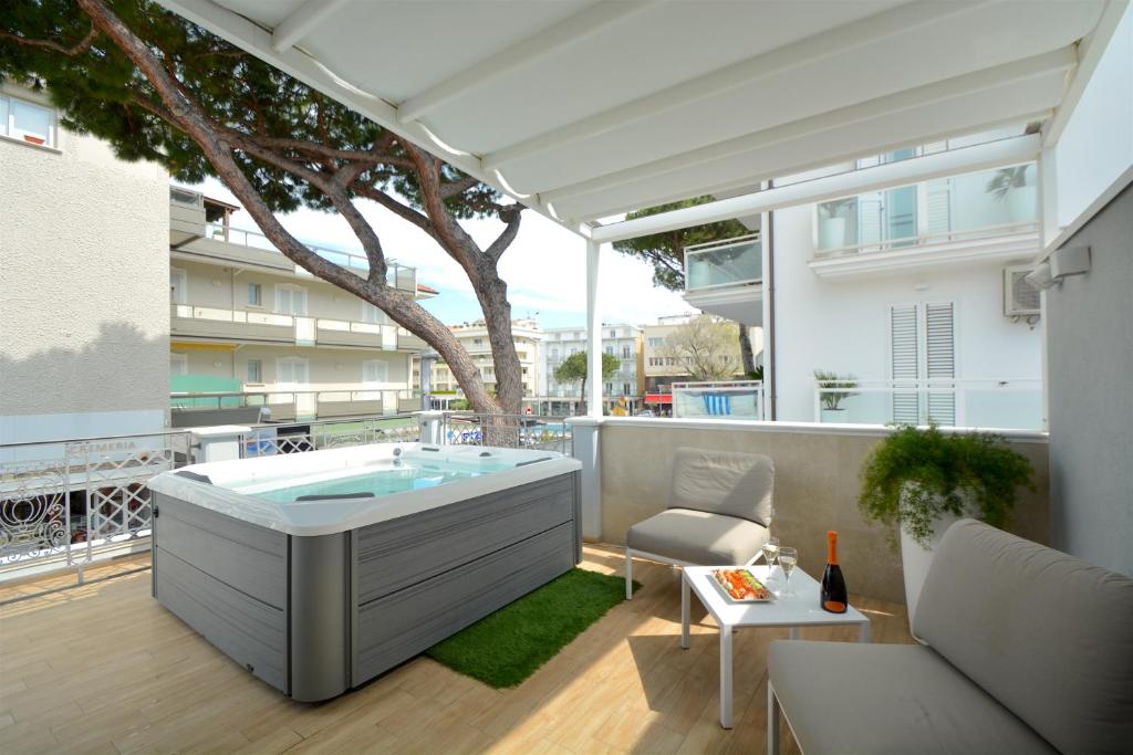 里乔内Prime Blue Suite - Appartamenti con jacuzzi privata的大楼阳台上的热水浴池