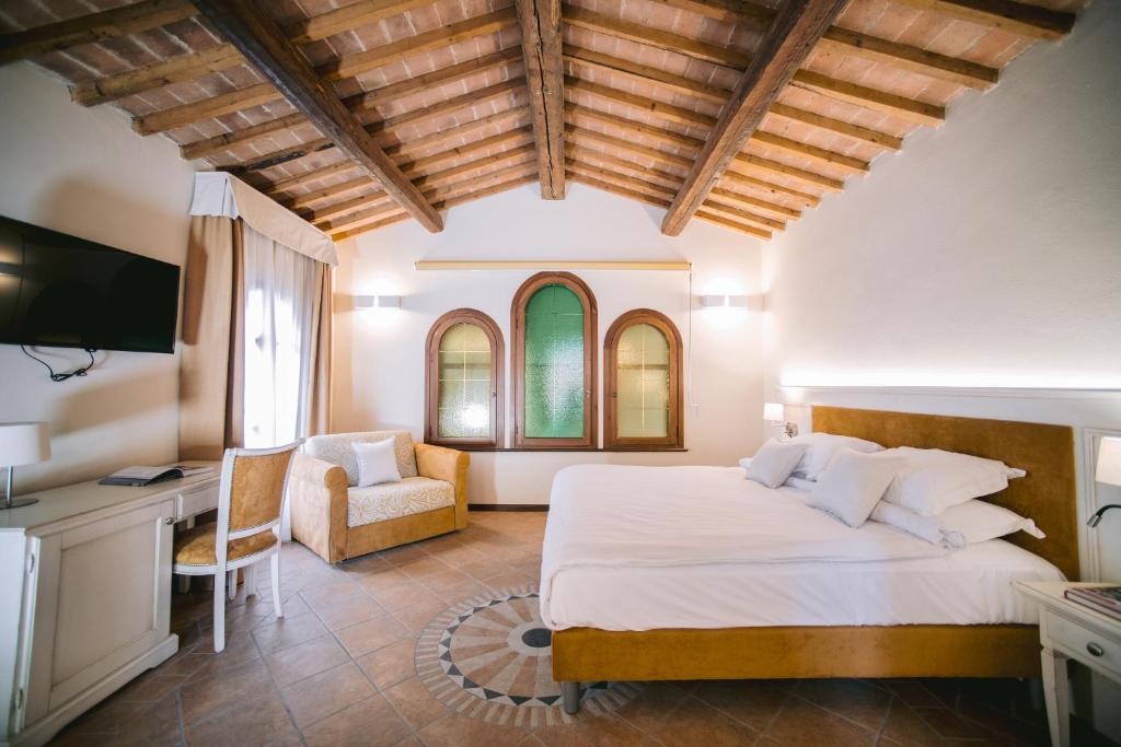 Mezzane di SottoBACCO D'ORO Wine & Relais的一间卧室配有一张床、一张桌子和一把椅子