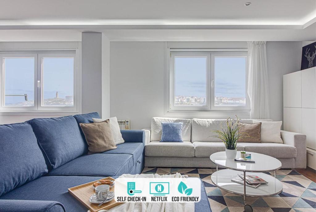 拉科鲁尼亚Riazor Ocean View Apartment的客厅配有蓝色的沙发和桌子