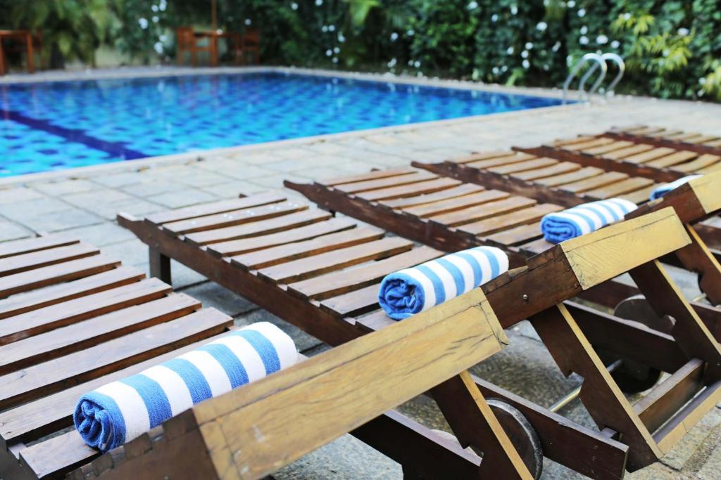 康提Hotel Casamara的游泳池旁的一排木凳