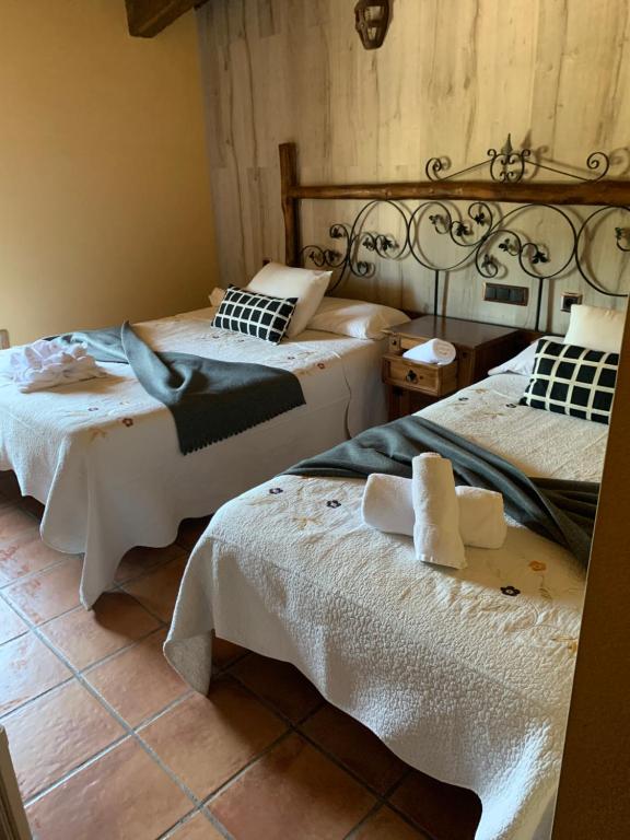 贝哈尔Hotel Rural Vistahermosa的一间卧室配有两张带白色床单的床。