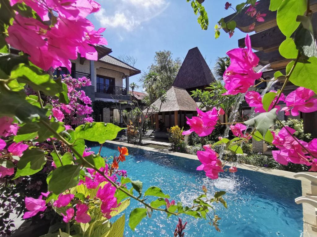 努沙杜瓦Artoria Dream Villas Bali的一座鲜花盛开的房子前的游泳池