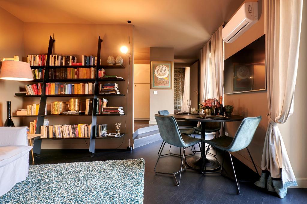 贝加莫上城麦宏姆度假屋的客厅配有桌椅和书架