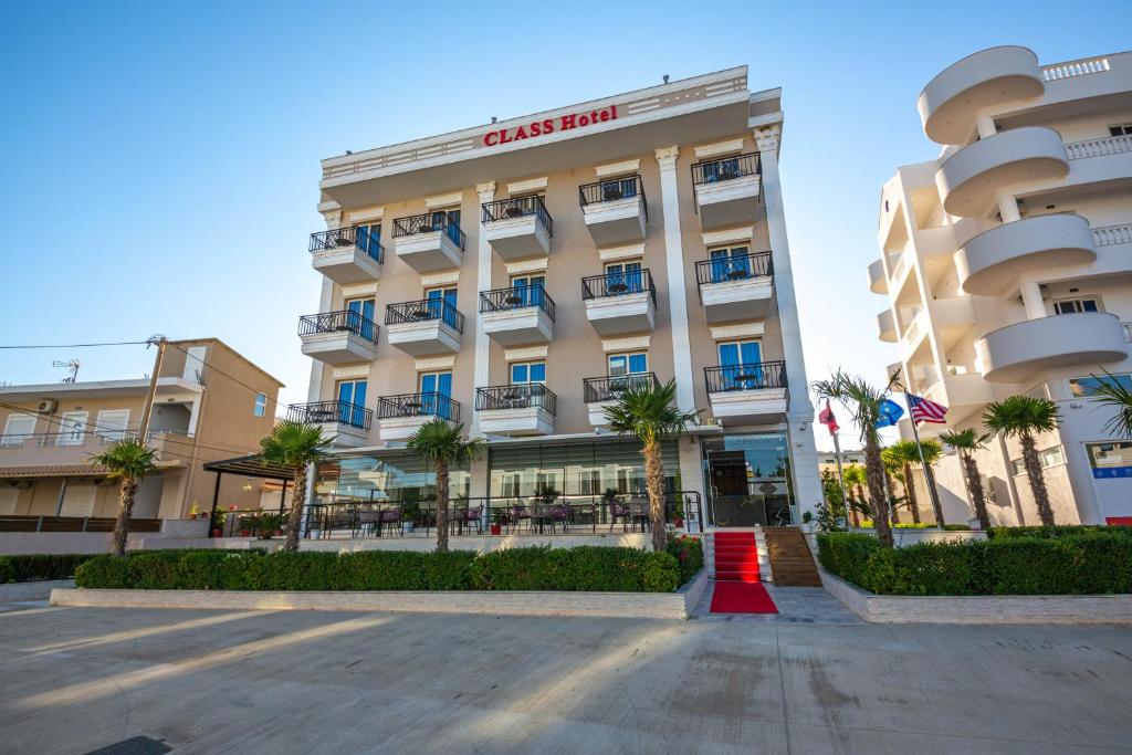 卡萨米尔CLASS Hotel的享有酒店前方棕榈树建筑的景致
