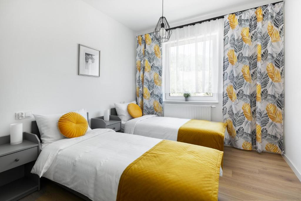 库多瓦-兹德鲁伊Apartamenty Wczasowa - komfort z rowerownią的一间卧室设有两张床和窗户。