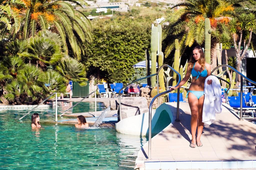 伊斯基亚地中海公园温泉酒店的穿着比基尼的女人在游泳池滑梯上走下