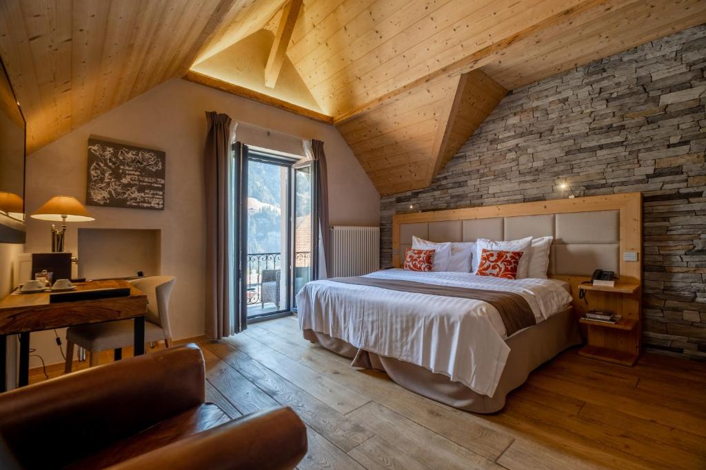 尚佩里国家Spa度假酒店的一间卧室设有一张大床和砖墙