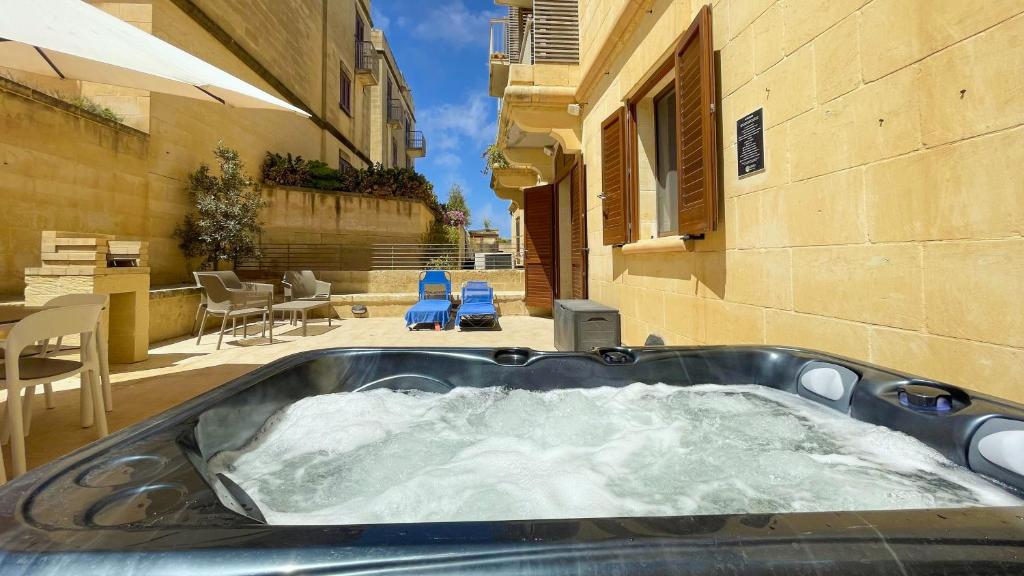 MġarrGee9Teen at Fort Chambray的大楼中央的热水浴池