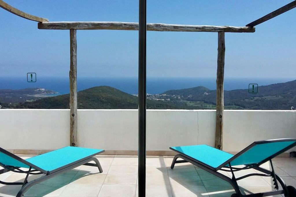 RoglianoRogliano Maison de charme avec vue panoramique的海景阳台上的2把蓝色椅子