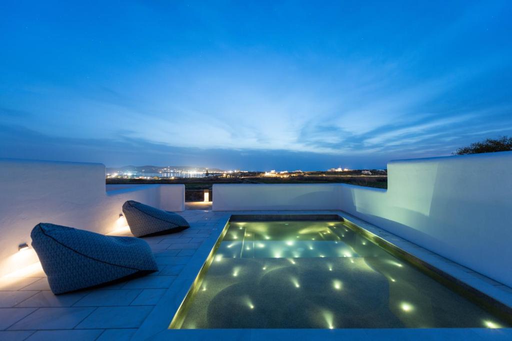帕罗斯岛Sersi Paros Villas & Suites的夜间屋顶的游泳池