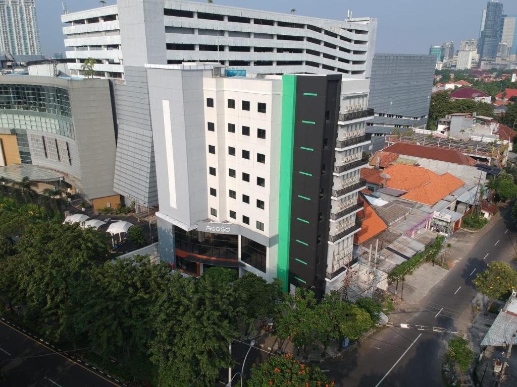 泗水Agogo Downtown Hotel Surabaya的一座高大的白色和绿色建筑