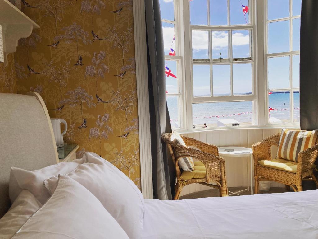韦茅斯白色悬崖宾馆的一间卧室配有一张床,享有海滩美景