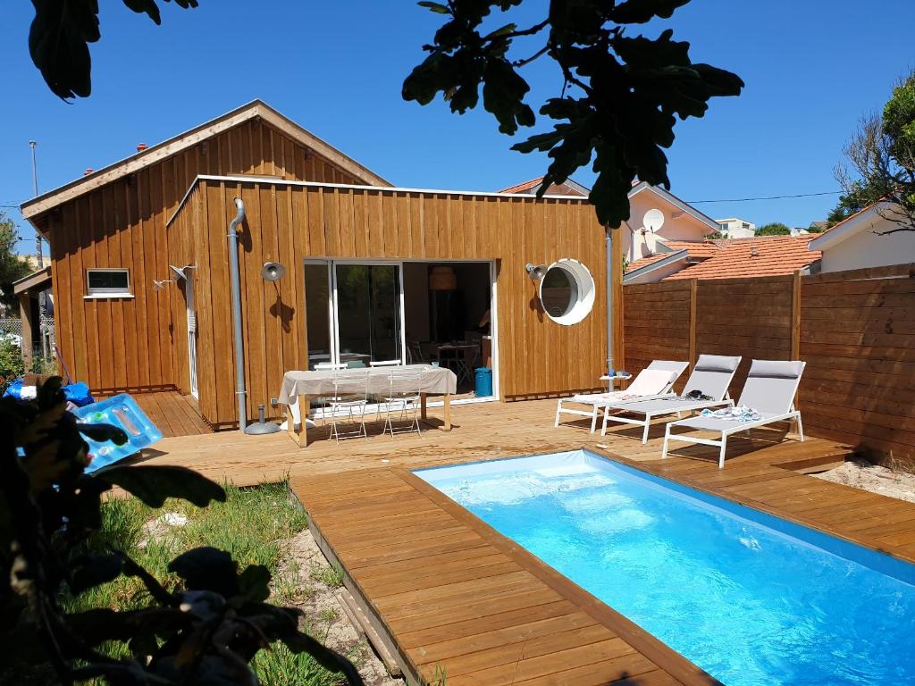拉卡诺Biby BeachHouse的一个带游泳池和房子的后院