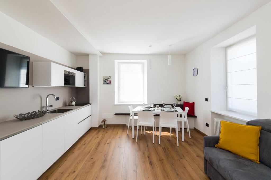 莱维科特尔梅Appartamento Levico的厨房以及带桌子和沙发的客厅。