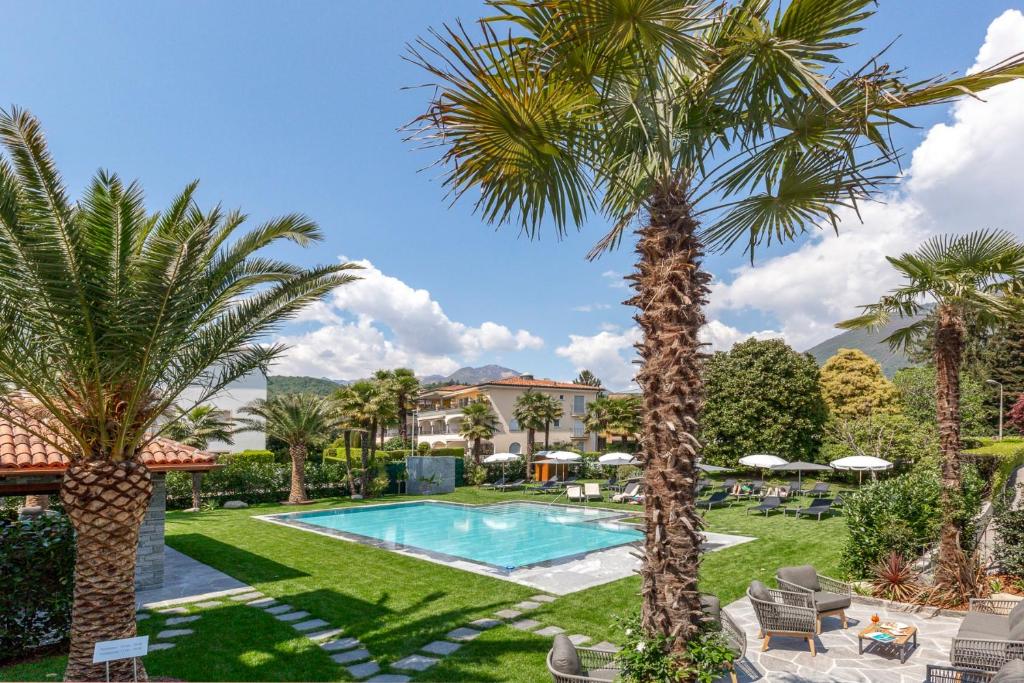 阿斯科纳阿斯科迷人别墅酒店的一个带游泳池和棕榈树的度假村