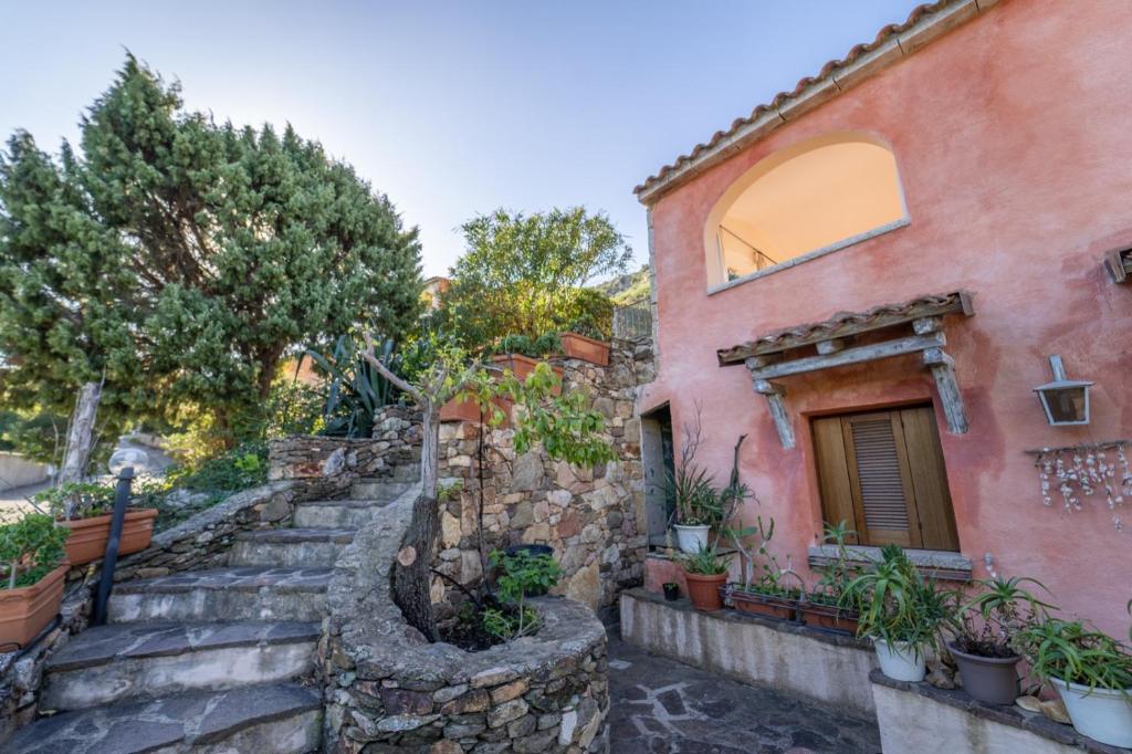 圣特奥多罗House in San Teodoro among the scents of Sardinia的石头房子,有楼梯通往建筑