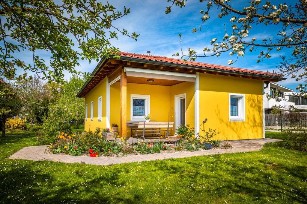 萨尔茨堡Ferienhaus Schlagerbauer Biohof的院子里的黄色房子,长凳