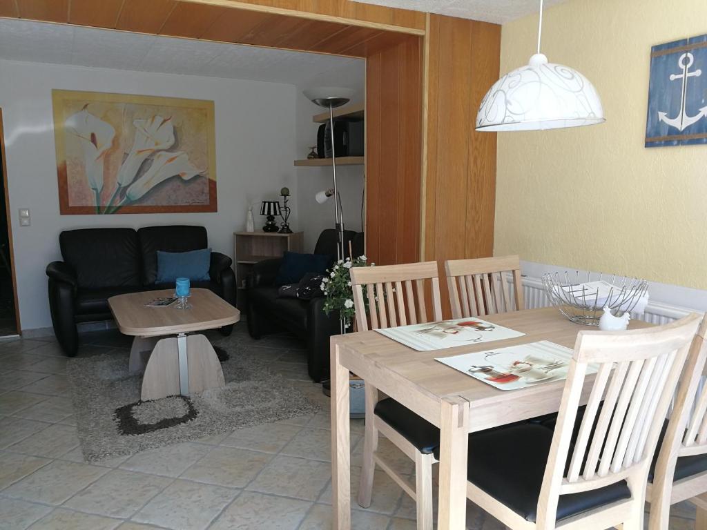 博尔滕哈根Ferienwohnung Mertins的客厅配有木桌和椅子