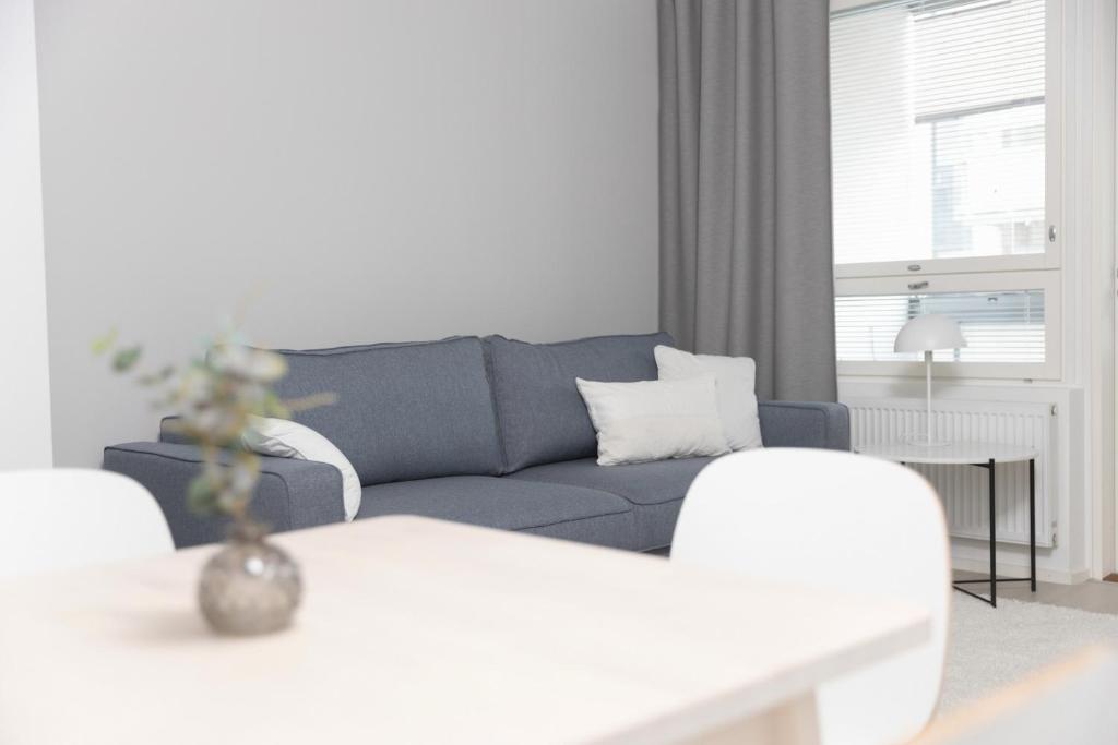 罗瓦涅米Studio Leppälä的客厅配有蓝色的沙发和桌子