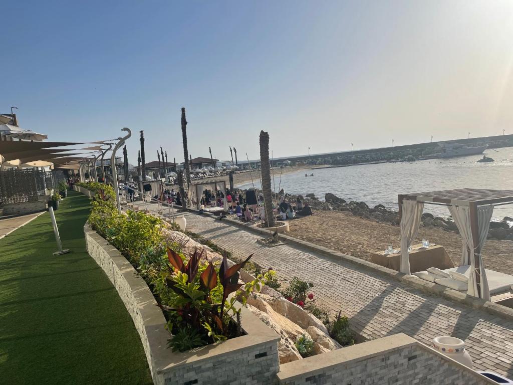 亚历山大Fleet Club Mahrousa的海滩上有一排桌子和 ⁇ ,水