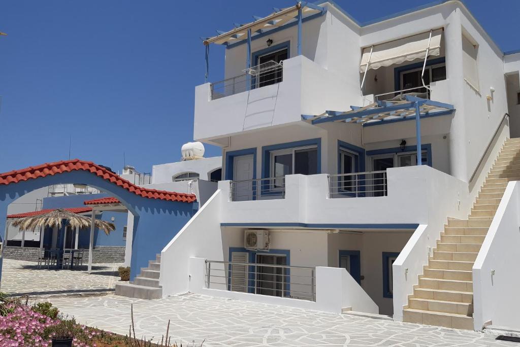 莫拉托斯Filia Apartments的海滩前有楼梯的大型白色建筑