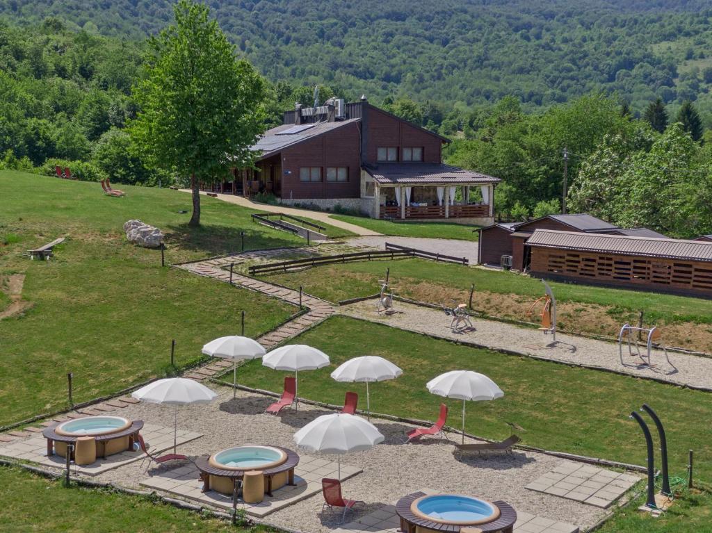塞里特雷尼科B&B Villa Irene Plitvice Lakes的享有公园的空中景致,配有桌子和遮阳伞