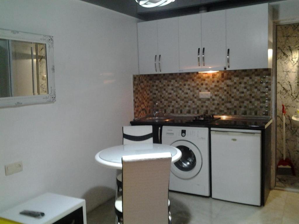 巴统Anna's Apartment的厨房配有桌子和洗衣机。