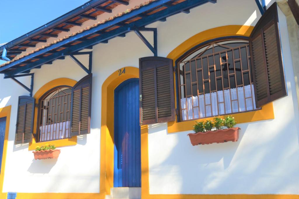 乌巴图巴Marujo Hostel的一座白色的建筑,里面装有窗户和植物