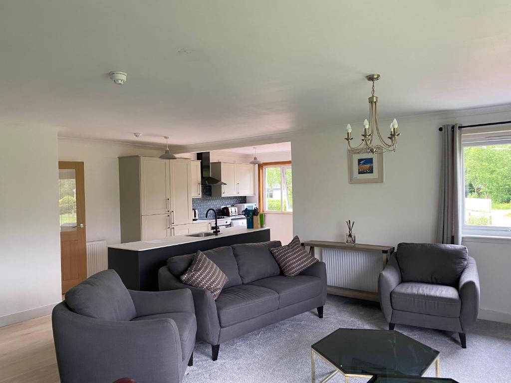 巴拉胡利什Lyn leven cottages的一间带两张沙发的客厅和一间厨房