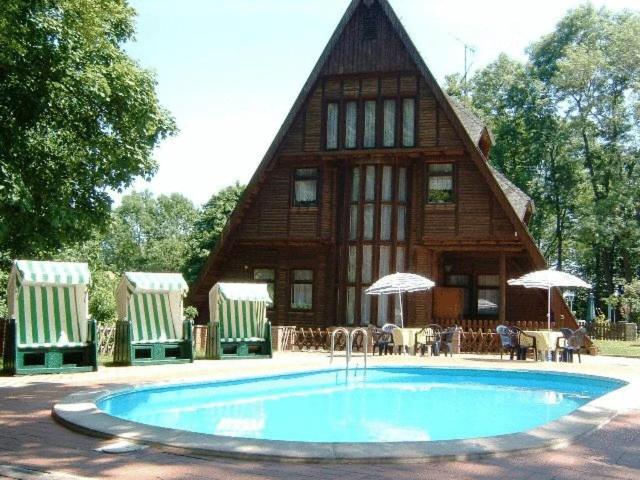 塔勒Ferienpark Rosstrappe的一座房子前面设有游泳池
