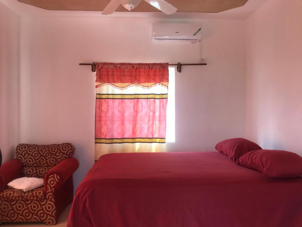 安东尼奥港Quiet Escape Long Bay的一间卧室设有红色的床和窗户。