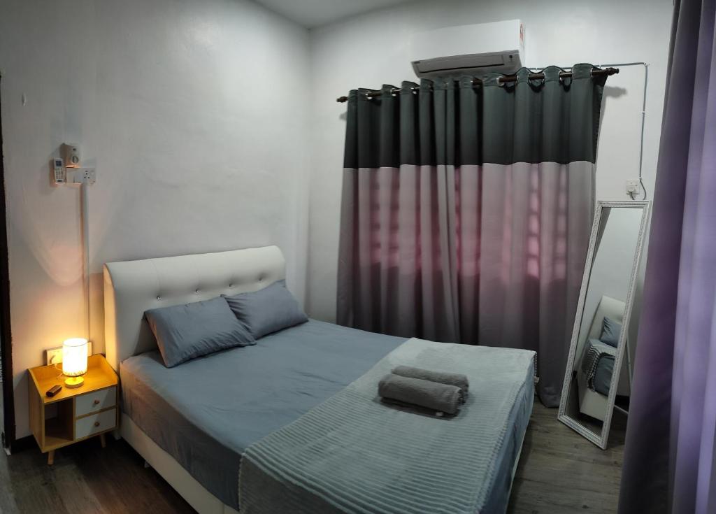 日得拉DARUL AMAN Homestay Jitra的一间小卧室,配有一张床和镜子