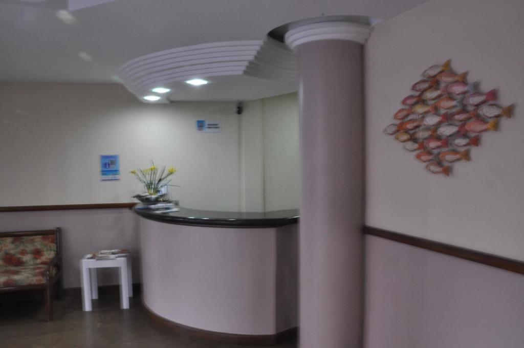瓜拉派瑞Hotel Raio de Sol的一间设有柱子和墙壁及桌子的房间