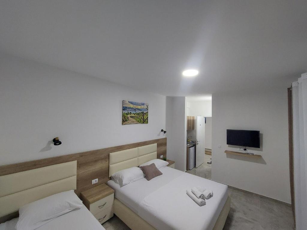 乌尔齐尼Apartments kupi ul rudaj 41的一间卧室配有两张床和一台平面电视