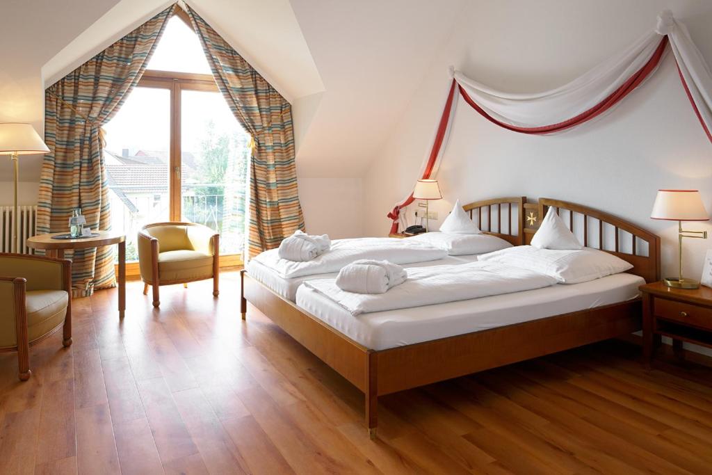 于伯林根约翰尼特克罗伊茨罗曼蒂克酒店的一间卧室设有一张床和一个大窗户