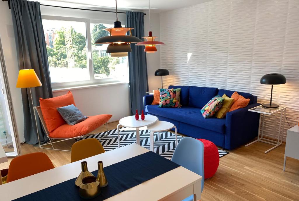 维也纳Brand New Cozy Apartment 10 min to city center的客厅配有蓝色的沙发和橙色椅子