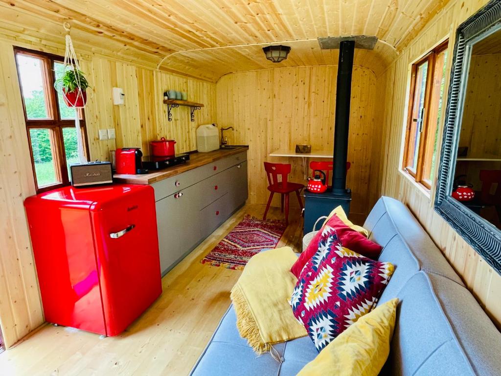 舒马瓦山区霍日采Maringotka Lipenka u Lipenské přehrady na Šumavě的客厅配有蓝色沙发和红色冰箱