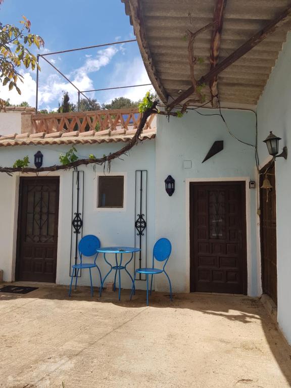 CádiarGranja de Matias的两把蓝色的椅子和一张桌子,位于房子前面