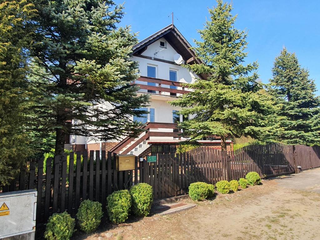 斯沃尔纳加西耶Przestronny, komfortowy dom的一座带黑色围栏和树木的房子
