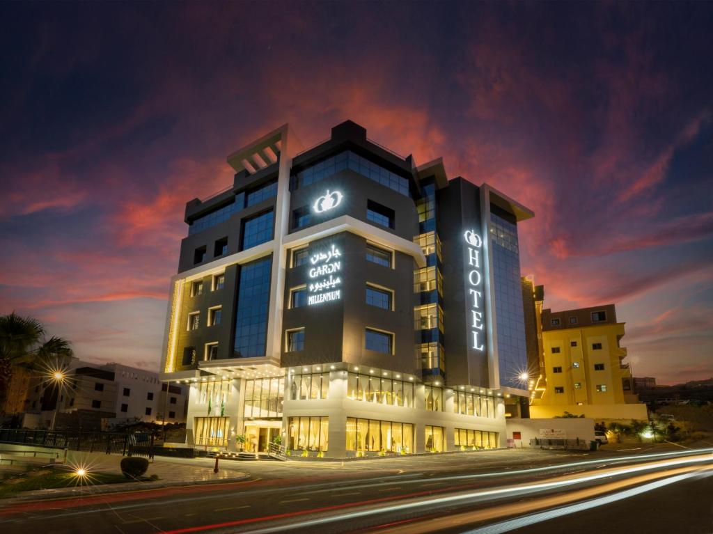 艾卜哈Abha Gardn Millennium Hotel的夜间有灯的酒店大楼