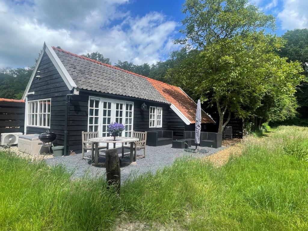 WijheNatuurhuisje - Gastenverblijf De Kleine Hazerij的小屋前面设有野餐桌