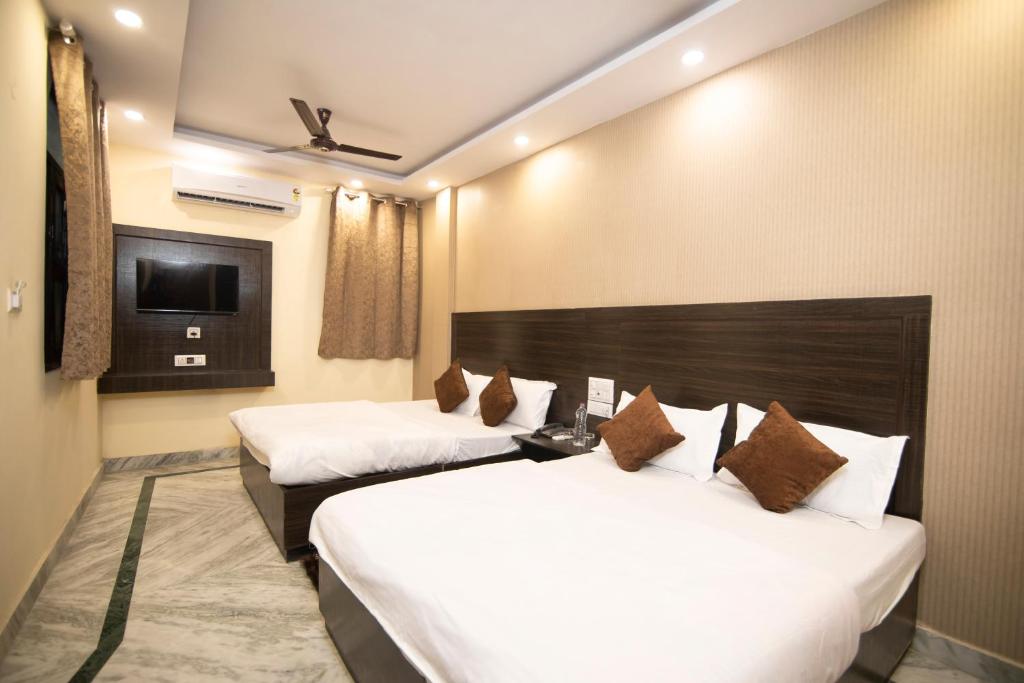 新德里Hotel Siddharth A Boutique Guest House的酒店客房设有两张床和电视。