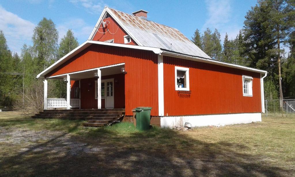 ÖverkalixVilla Polarktis的一座橙色和白色的房子,里面放着绿色的垃圾
