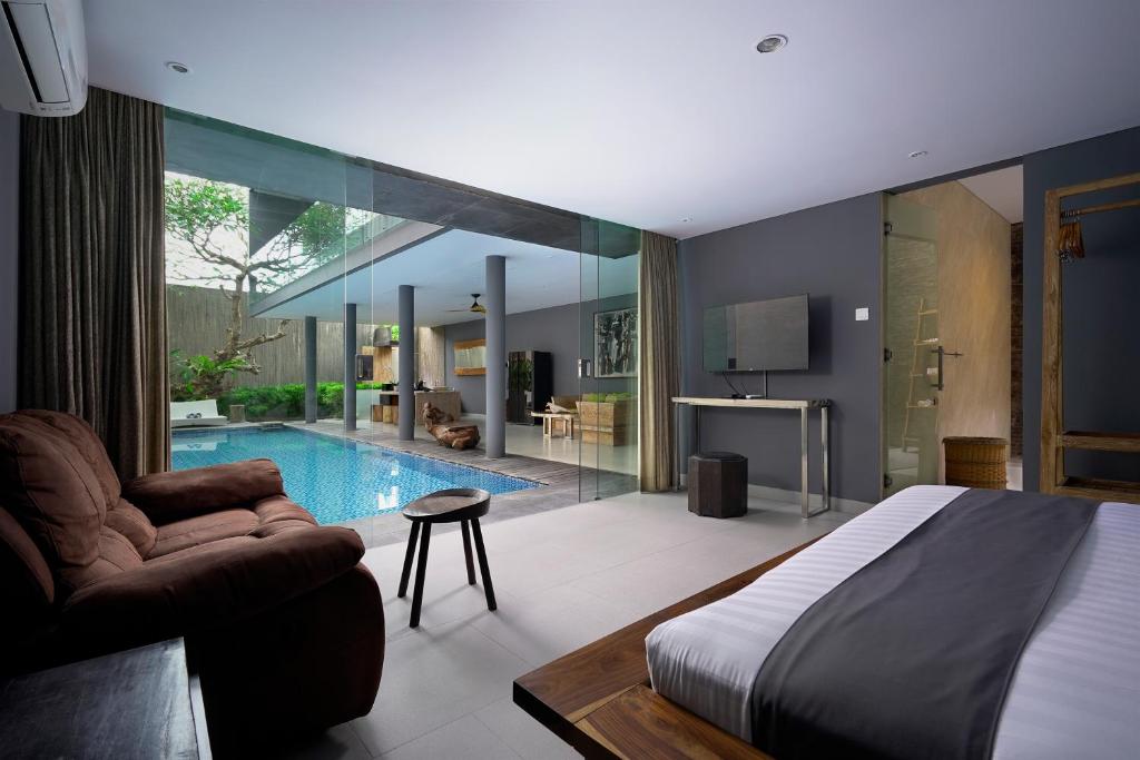 坎古Sandhya Villa Canggu Echo Beach的一间卧室设有一张床和一个游泳池