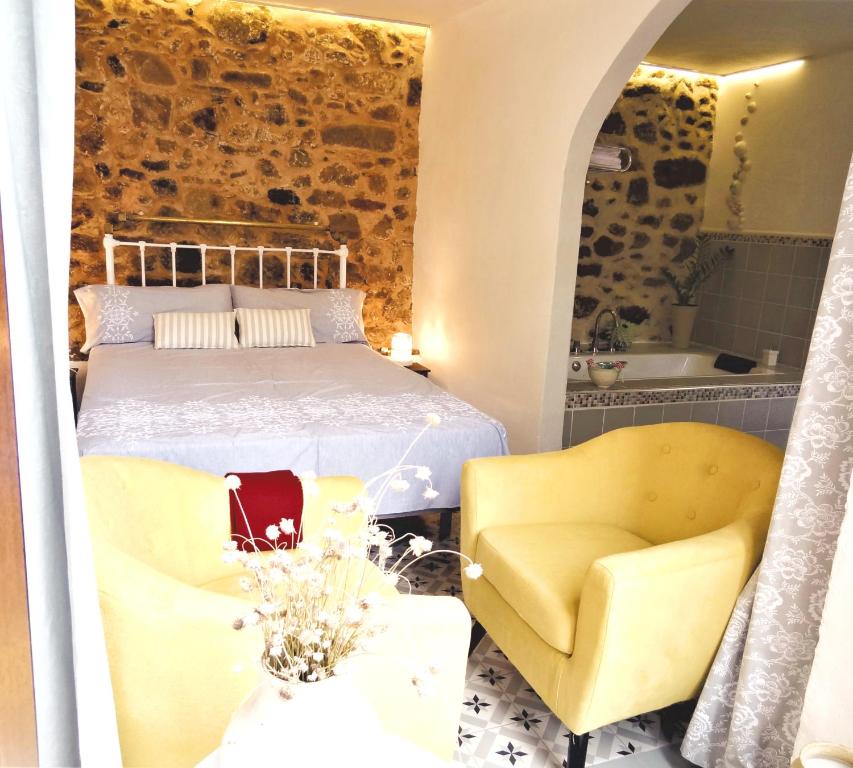 阿雷纳斯德圣佩德罗La Solana的一间卧室配有一张床、两把椅子和一个浴缸