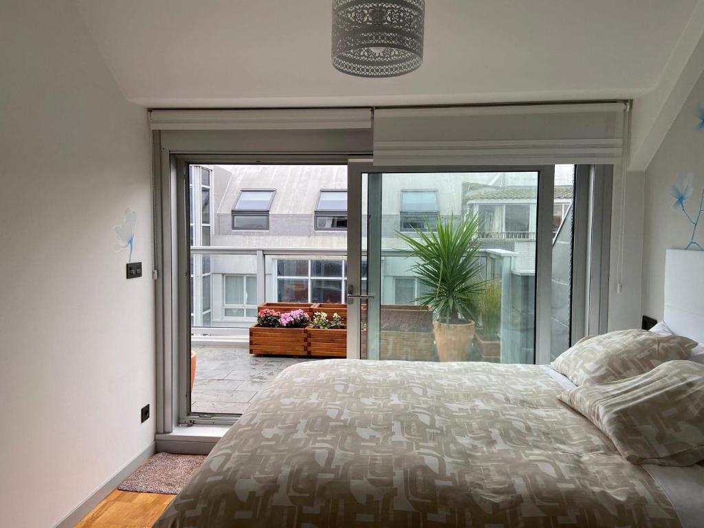 拉科鲁尼亚Penthouse with terrace and views near Oza's beach的一间卧室设有一张床和一个大窗户